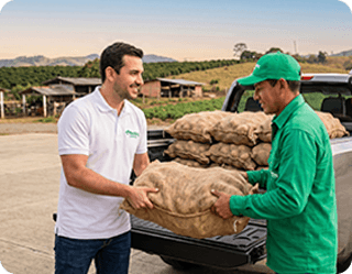 Dos hombres cargando sacos de cosecha en una camioneta, representando nuestras soluciones de movilidad para el sector agro