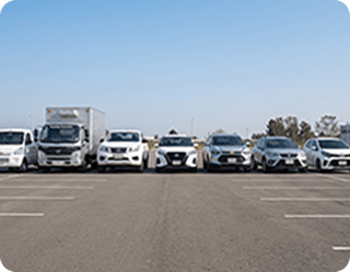 Fila de diversos vehículos, incluyendo camiones, camionetas y automóviles, representando la variedad de nuestro portafolio de servicios